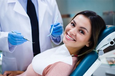 Smiling patient reclining in treatment chair during dental appointment