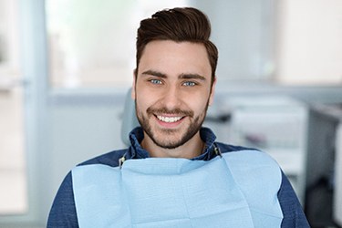 Male patient smiling after successful dental implant salvage