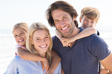 Smiling family of four on beach
