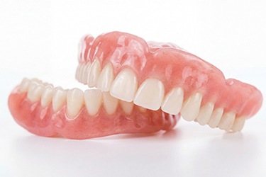 Full set of dentures pictured against white background