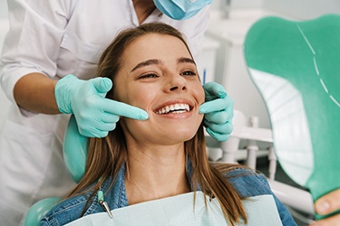 Happy dental patient looking in mirror