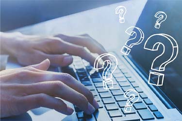 hands typing questions on a laptop