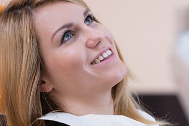 Young woman in dental chair with beautiful smile