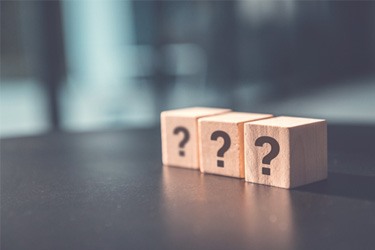 Three wooden blocks with question marks on them