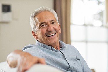 Senior man enjoying results of denture stabilization in Schenectady