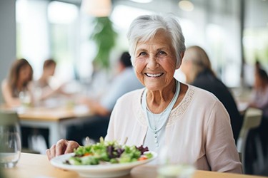 Smiling senior woman eating a salad