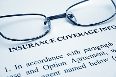 Close-up of insurance paperwork and pair of eyeglasses