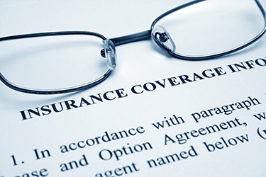 Close-up of insurance paperwork and pair of eyeglasses