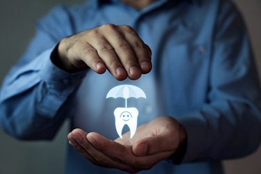 Dental insurance icon between man’s hands