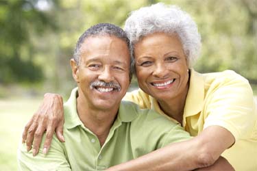 Smiling couple with dental implants in Schenectady