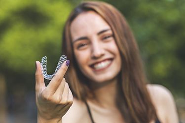 Smile woman holding invisalign