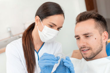 Patient and dentist discussing Invisalign treatment during checkup