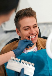 Man smiling while looking in mirror in dental chair