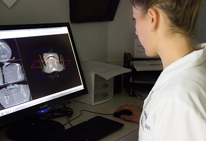 Dentist examining x-rays on computer monitor