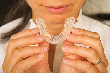 Patient holding Invisalign aligner