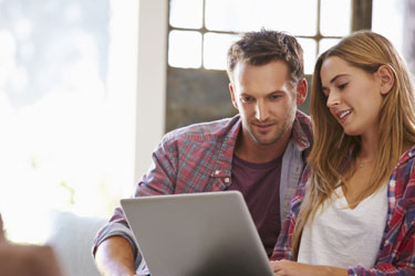 Couple in plaid researching something on the computer