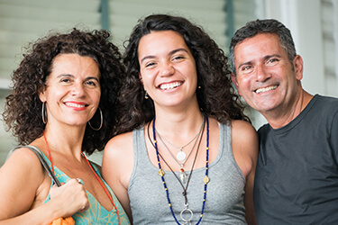 Parents and adult daughter smiling