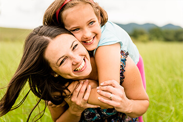 Happy mother and daughter smiling outdoors