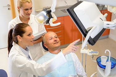 Male patient and dental professionals discussing Invisalign treatment