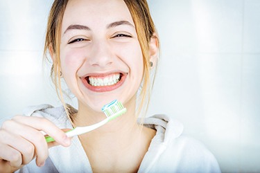 Woman smiling and holding toothbrush