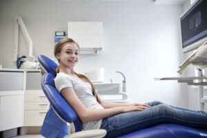 Smiling teen girl in dental treatment chair 