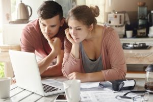 attractive couple looking at laptop in kitchen