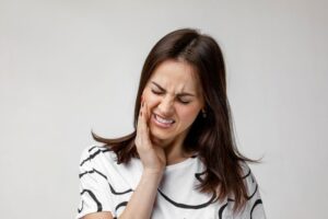 Woman grimacing due to tooth pain
