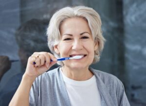 Senior woman brushing her teeth 