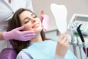 Cosmetic dental patient holding hand mirror