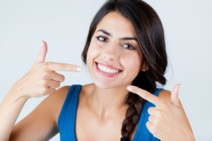 Happy woman showing off dental implants in Schenectady