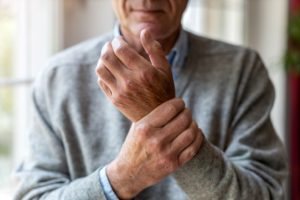 Man with RA holding his wrist