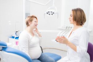 Pregnant woman talking with dental team member